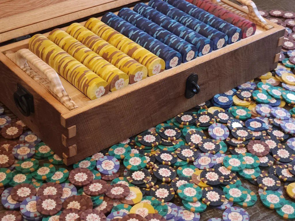 A handcrafted wooden chip case filled with rows of clay poker chips