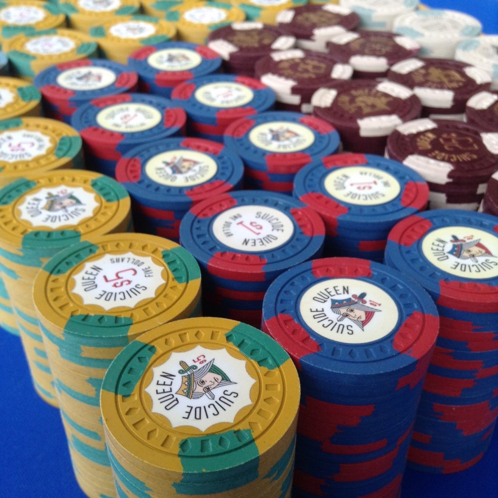 Stacks of the Suicide Queen custom set — scalloped inlays on yellow, blue and maroon chips with contrasting edge spots